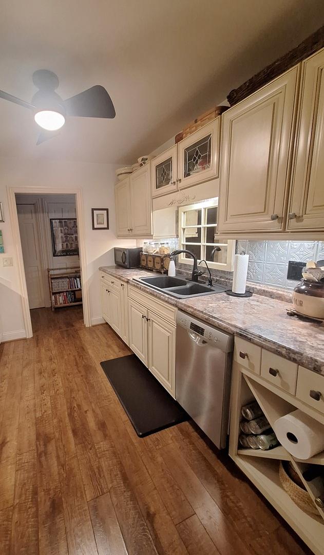 7323 Heritage Ct Unit 1D, Frankfort, IL 60423 - kitchen featuring a sink, stainless steel dishwasher, wood-type flooring, and tasteful backsplash