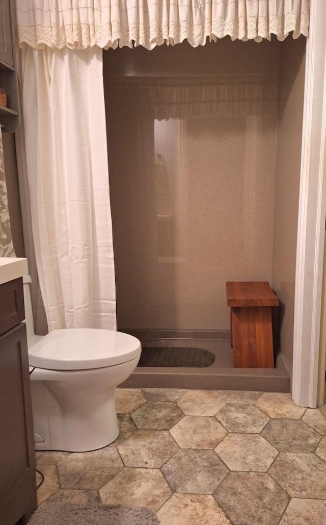 7323 Heritage Ct Unit 1D, Frankfort, IL 60423 - full bathroom featuring toilet, stone finish flooring, a shower with shower curtain, and vanity