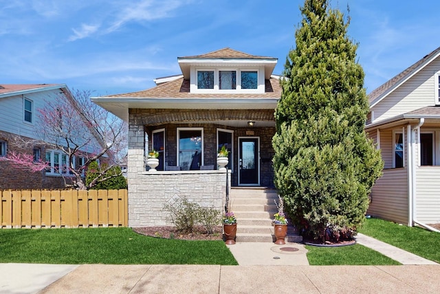 5650 W Grace St, Chicago, IL 60634 - bungalow featuring a porch, a shingled roof, fence, and stone siding