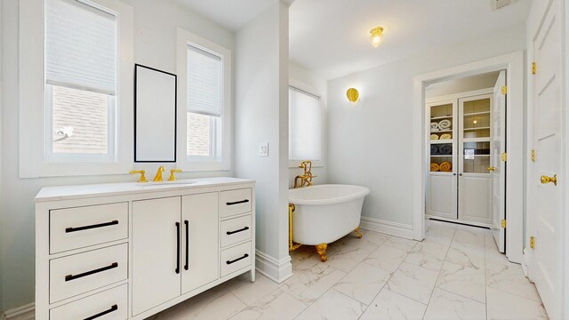 5650 W Grace St, Chicago, IL 60634 - bathroom with baseboards, marble finish floor, a freestanding bath, and vanity