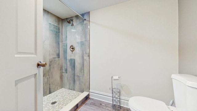 5650 W Grace St, Chicago, IL 60634 - full bathroom featuring a tile shower, toilet, and wood finished floors