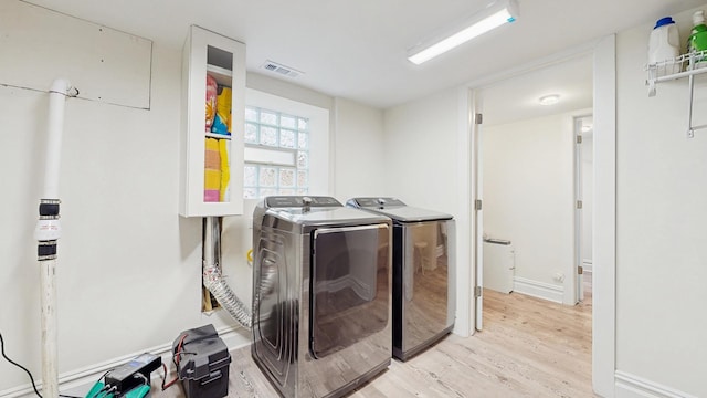 5650 W Grace St, Chicago, IL 60634 - washroom featuring washing machine and clothes dryer, laundry area, light wood-style flooring, baseboards, and visible vents