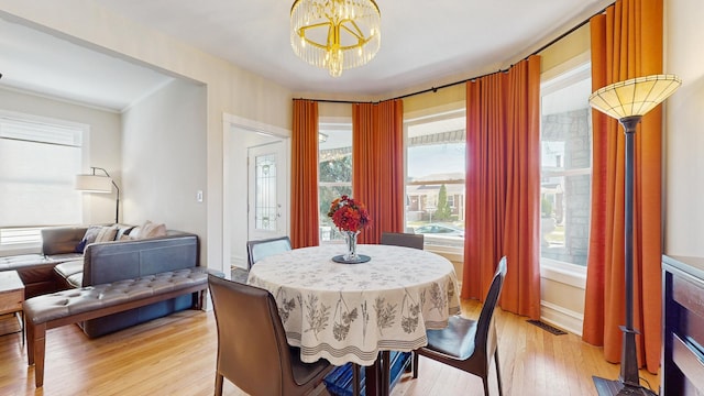 5650 W Grace St, Chicago, IL 60634 - dining room featuring light wood-style floors, baseboards, a chandelier, and visible vents