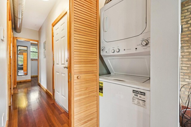 1247 W Roscoe St Unit 2, Chicago, IL 60657 - laundry area featuring stacked washing machine and dryer, dark wood-style floors, and baseboards