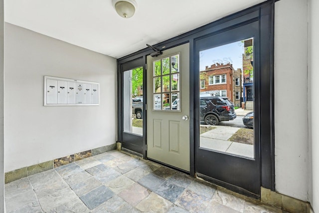1247 W Roscoe St Unit 2, Chicago, IL 60657 - doorway featuring stone tile floors, baseboards, and mail area
