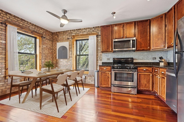 1247 W Roscoe St Unit 2, Chicago, IL 60657 - kitchen with stainless steel appliances, dark wood finished floors, plenty of natural light, and brick wall