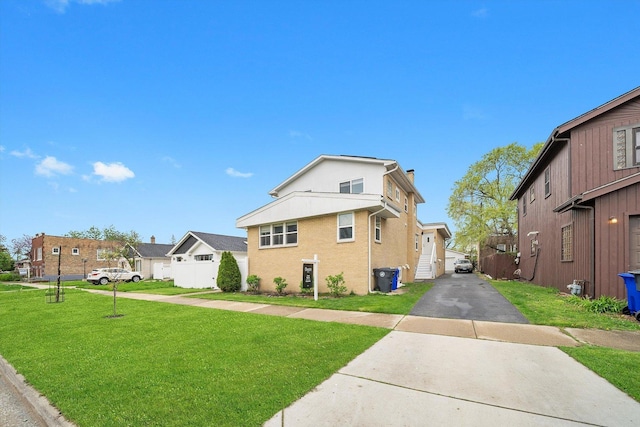 exterior space with a lawn, a residential view, and aphalt driveway