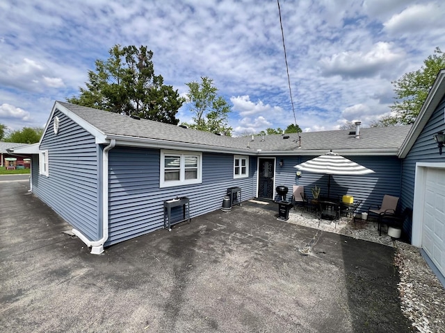 1309 Eureka St, Urbana, IL 61801 - back of house featuring a patio and roof with shingles