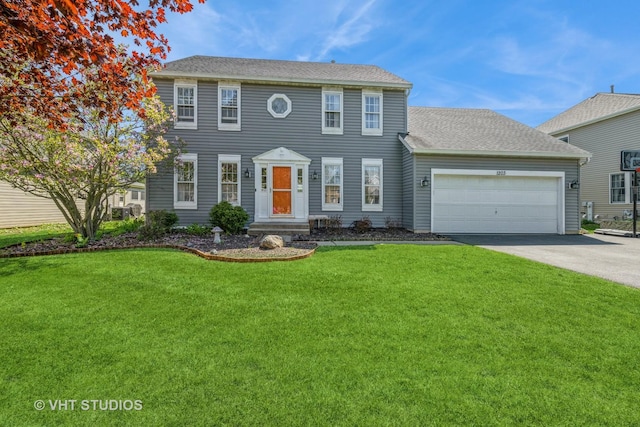 colonial home featuring driveway, a front lawn, and an attached garage