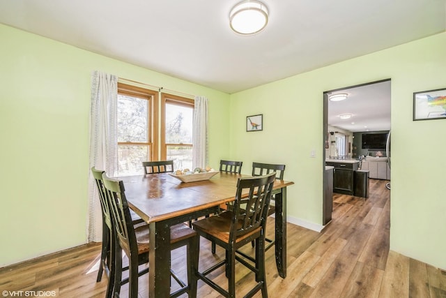 dining area featuring light wood-style flooring and baseboards