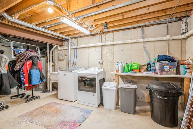 washroom with washing machine and clothes dryer and gas water heater