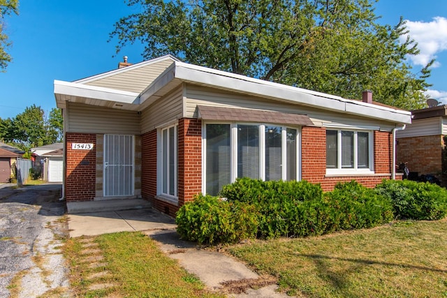 15413 Dobson Ave, Dolton, IL 60419 - view of front of home featuring an outdoor structure, a front lawn, and brick siding