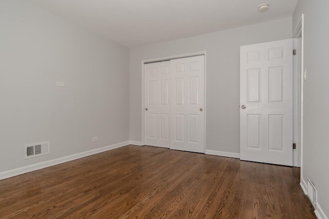 15413 Dobson Ave, Dolton, IL 60419 - unfurnished bedroom with a closet, baseboards, dark wood-type flooring, and visible vents