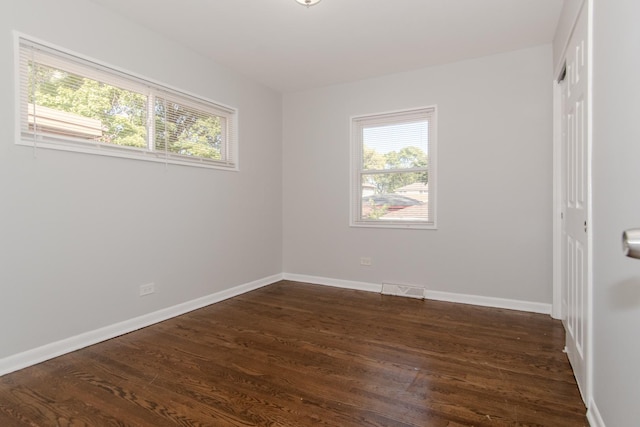 15413 Dobson Ave, Dolton, IL 60419 - spare room with baseboards, dark wood-style floors, and a healthy amount of sunlight