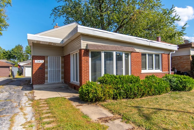 15413 Dobson Ave, Dolton, IL 60419 - view of front facade with brick siding, an outbuilding, and a front yard
