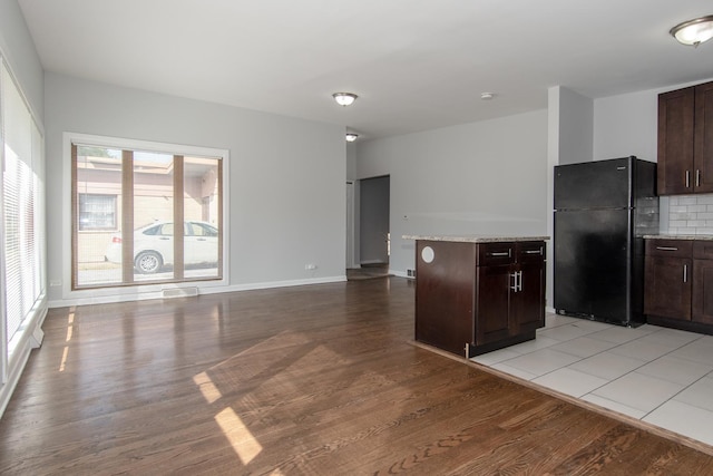 15413 Dobson Ave, Dolton, IL 60419 - kitchen with light wood-style floors, light stone counters, freestanding refrigerator, and dark brown cabinets