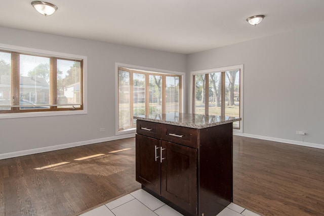15413 Dobson Ave, Dolton, IL 60419 - kitchen with wood finished floors, a kitchen island, dark brown cabinets, baseboards, and light stone counters