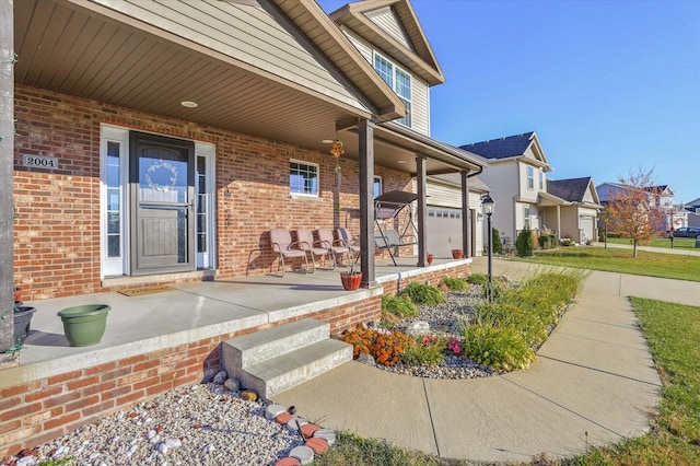 view of exterior entry with covered porch and brick siding