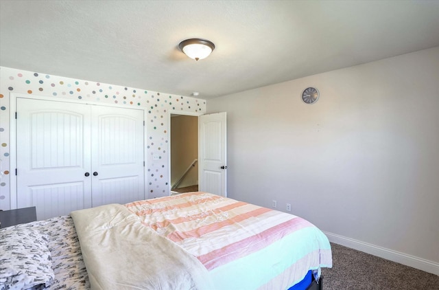 carpeted bedroom featuring baseboards and a closet
