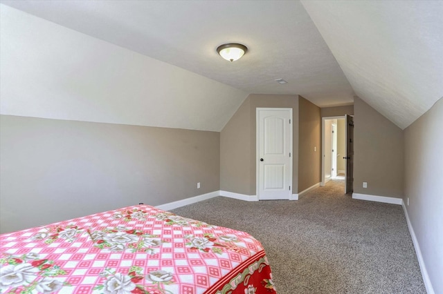 carpeted bedroom with baseboards and lofted ceiling