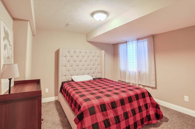 bedroom with carpet floors, baseboards, and a textured ceiling