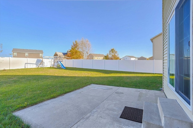 view of yard featuring a playground, a patio, and a fenced backyard