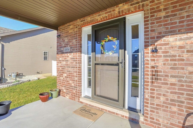 view of exterior entry featuring brick siding