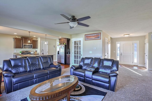 living area with ceiling fan, light carpet, baseboards, and recessed lighting