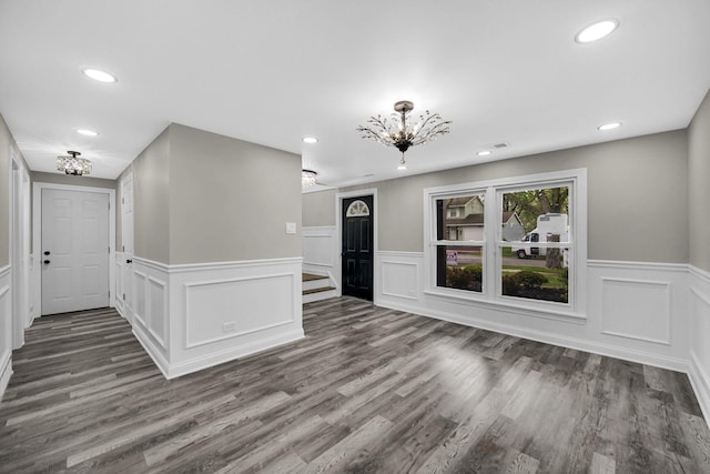 foyer with a chandelier, recessed lighting, a wainscoted wall, and wood finished floors