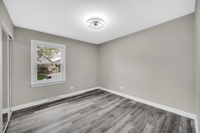 spare room with wood finished floors and baseboards