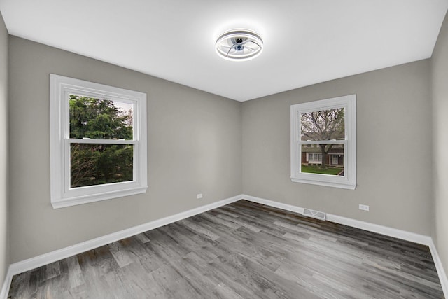 spare room featuring wood finished floors and baseboards