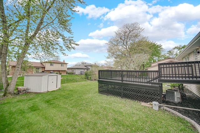 view of yard featuring a storage unit, a deck, cooling unit, and an outdoor structure