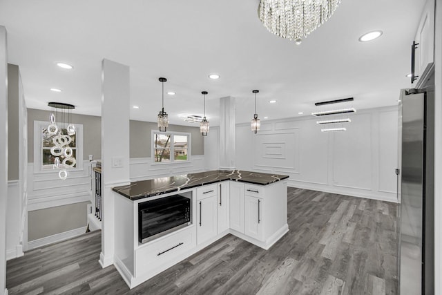 kitchen with a decorative wall, freestanding refrigerator, white cabinetry, dark wood finished floors, and recessed lighting
