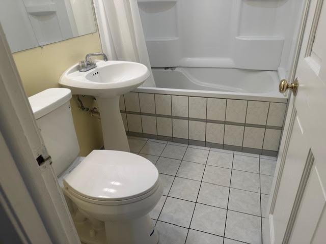 8901 N Western Ave Unit 116, Des Plaines, IL 60016 - bathroom with tiled shower / bath combo, tile patterned floors, and toilet