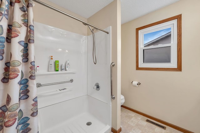bathroom featuring toilet, a textured ceiling, baseboards, curtained shower, and visible vents