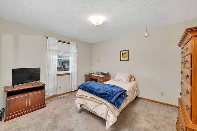 carpeted bedroom with a textured ceiling, visible vents, and baseboards
