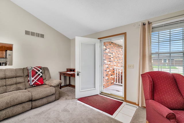 living room featuring tile patterned flooring, visible vents, and lofted ceiling
