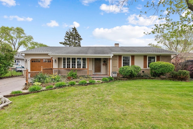single story home with covered porch, a front yard, a chimney, brick siding, and an attached garage