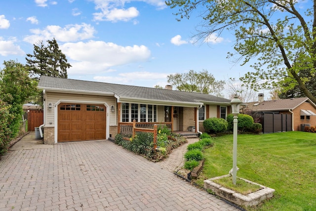 ranch-style house featuring an attached garage, a porch, a front yard, a chimney, and decorative driveway