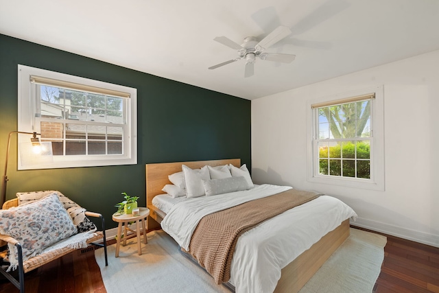 bedroom featuring baseboards, a ceiling fan, and hardwood / wood-style flooring