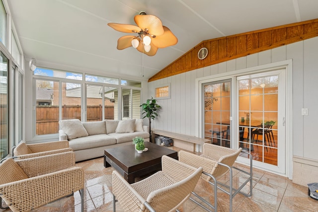 sunroom with an outdoor living space, a ceiling fan, wood walls, and lofted ceiling