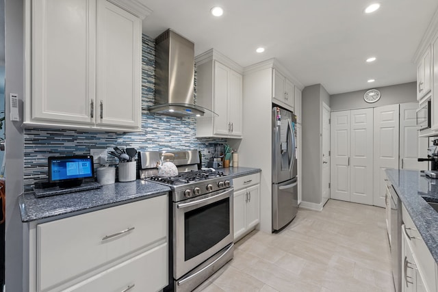 kitchen with wall chimney range hood, recessed lighting, white cabinetry, tasteful backsplash, and stainless steel appliances