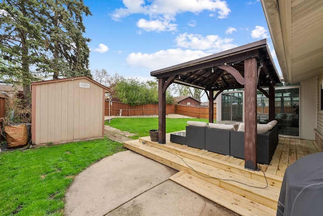 view of yard with a deck, a fenced backyard, an outdoor living space, a storage unit, and a gazebo