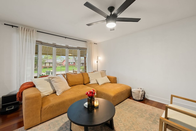 living area with baseboards, a ceiling fan, and wood finished floors