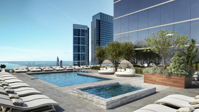pool with a patio and a hot tub