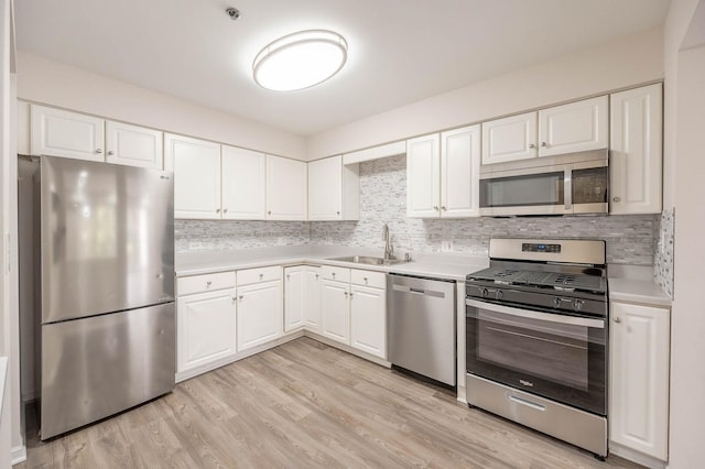 kitchen with white cabinetry, light countertops, stainless steel appliances, and tasteful backsplash