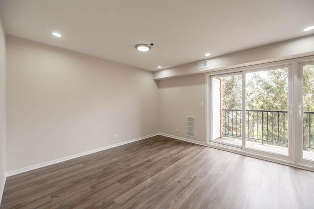 empty room featuring recessed lighting, baseboards, visible vents, and dark wood finished floors