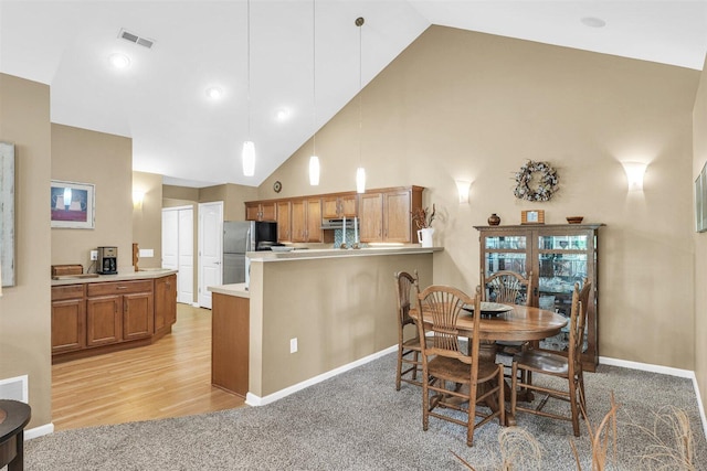 2715 J T Coffman Dr Unit 2715, Champaign, IL 61822 - dining space with high vaulted ceiling, light colored carpet, baseboards, and light wood-style flooring