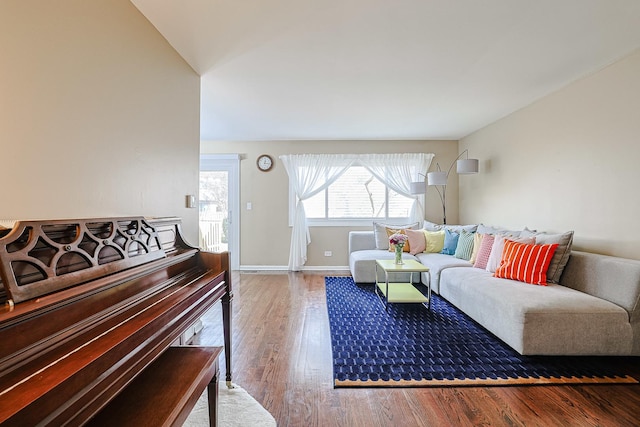 living area with baseboards and wood finished floors