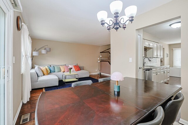 dining area featuring a chandelier, baseboards, visible vents, and wood finished floors